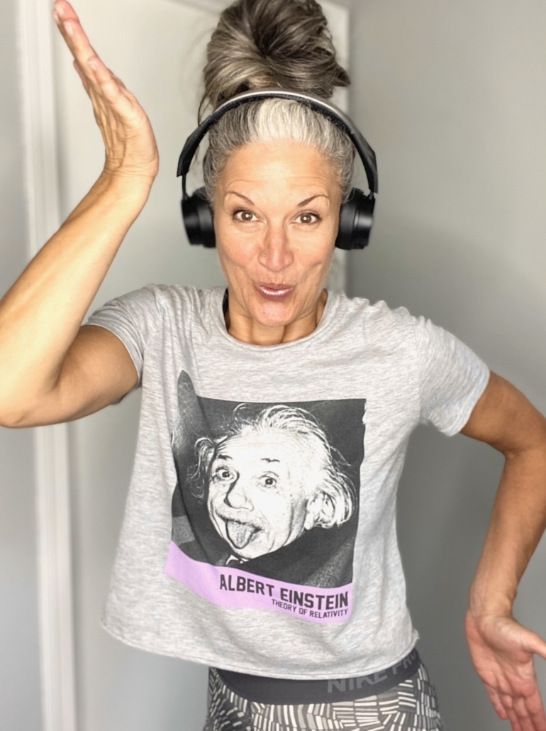 Theresa sticking her tongue out, wearing headphones and an Einstein t-shirt